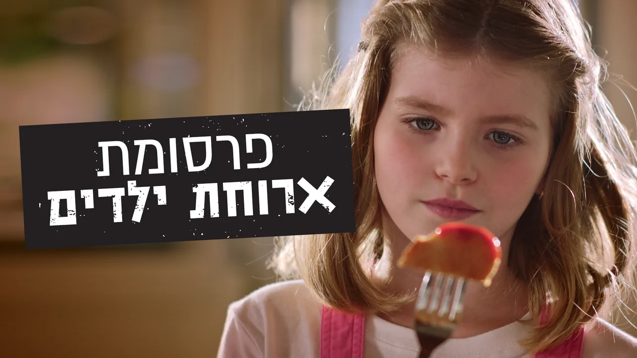 פריים מתוך הפרסומת: ילדה מביטה בחתיכת עוף על מזלג, לצד הכיתוב "פרסומת ארוחת ילדים"